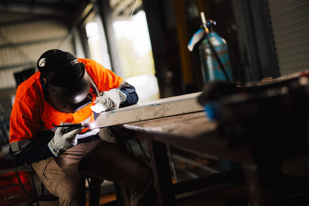 Baxter fabricator welding a steel assembly