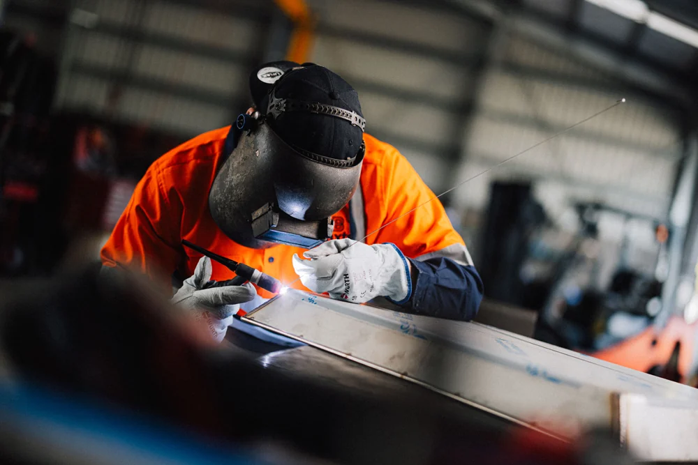 Baxter engineer welding a fabricated steel assembly