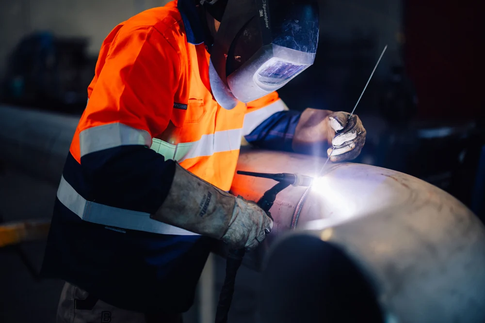 Baxter engineer welding a cylindrical steel component in Rolleston